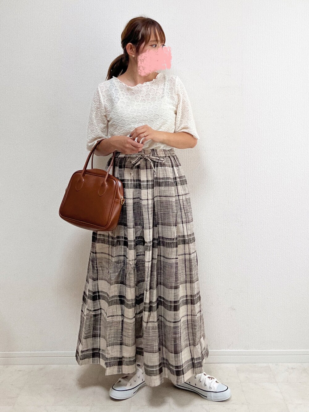 ベージュ系のスカート、ホワイト系のスニーカー、ブラウン系のハンドバッグを着用したレディースの夏コーディネートの3枚目の写真
