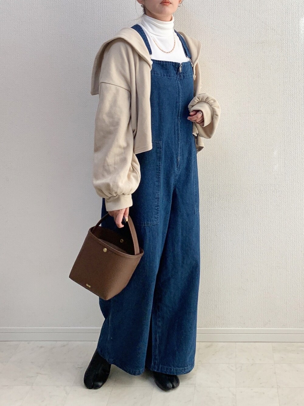 ブルー系のオールインワン・サロペット、グリーン系のシャツ/ブラウス、ブラック系のバッグを着用したレディースの冬コーディネートの3枚目の写真