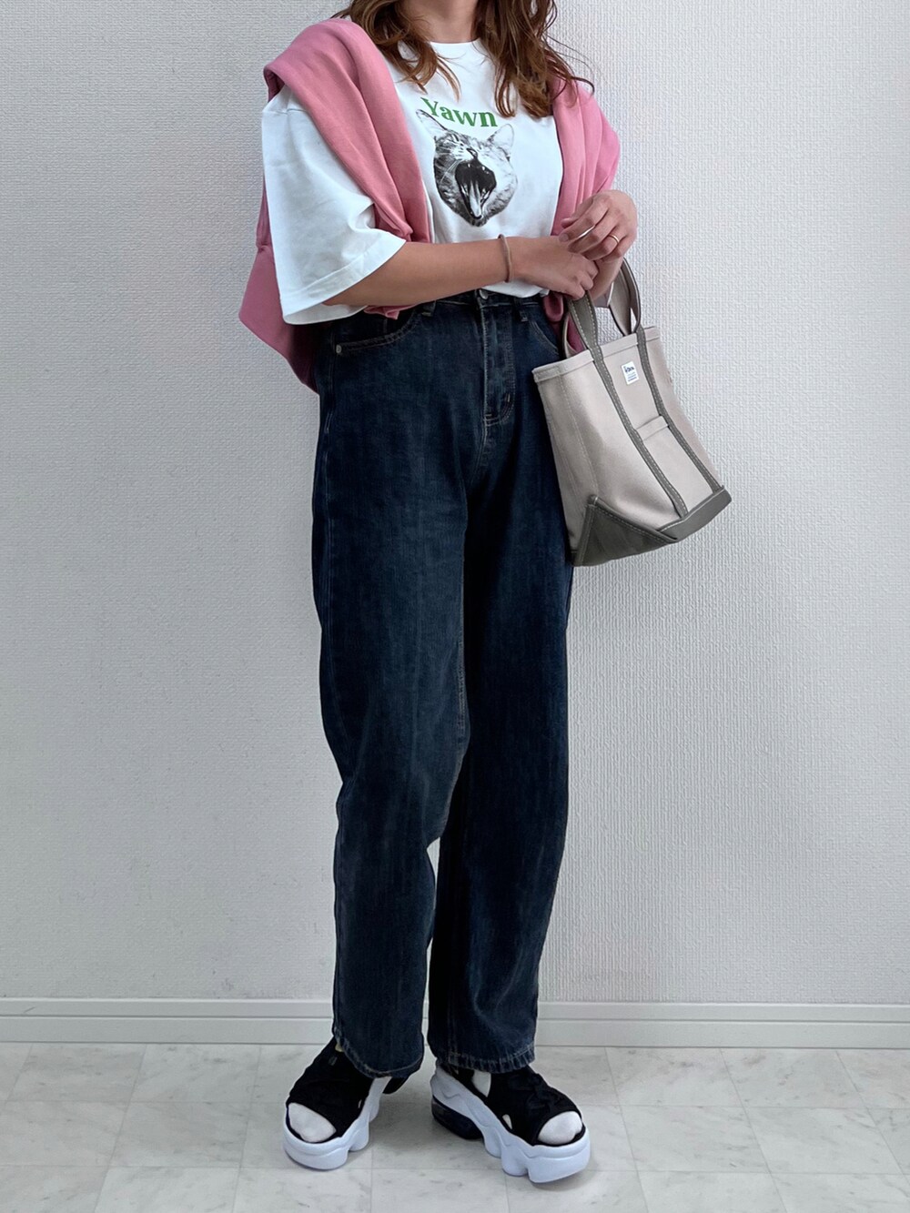 ホワイト系のTシャツ/カットソー、ブラック系のデニムパンツ、ピンク系のトップスを着用したレディースの春コーディネートの4枚目の写真