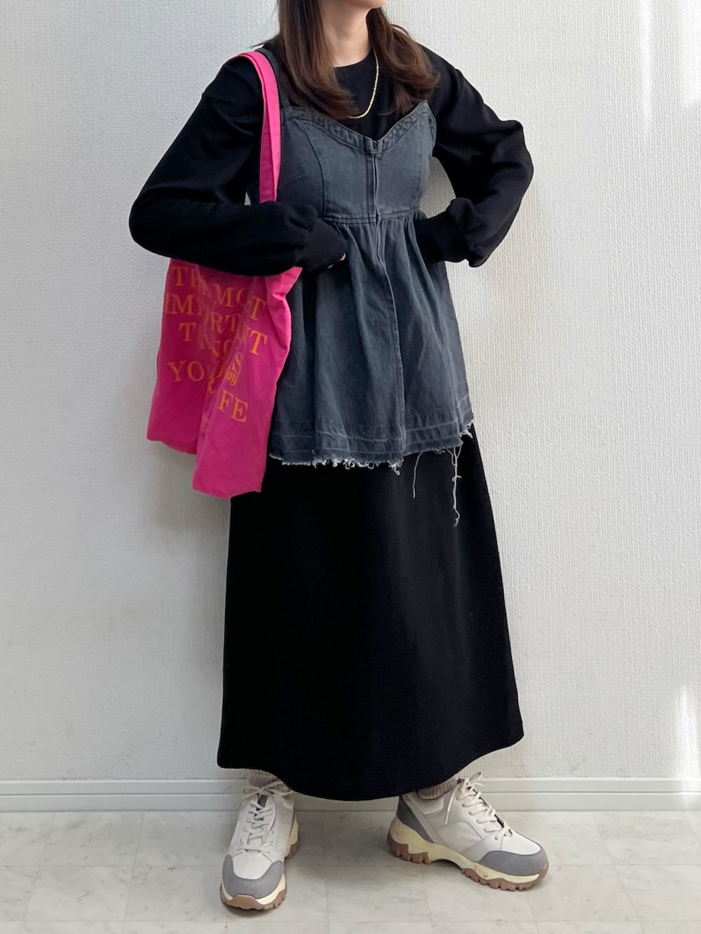 ブラック系のワンピース、ベージュ系のスニーカーを着用したレディースの冬コーディネートの3枚目の写真