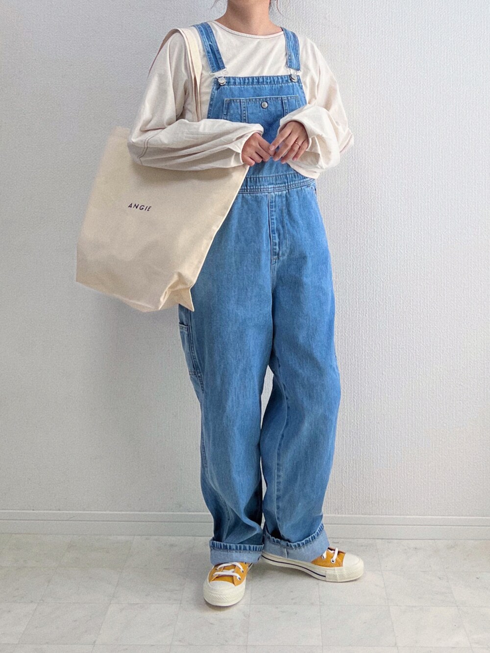 ベージュ系のTシャツ/カットソー、ブルー系のサロペット/オーバーオール、ホワイト系のトートバッグを着用したレディースの春コーディネートの2枚目の写真
