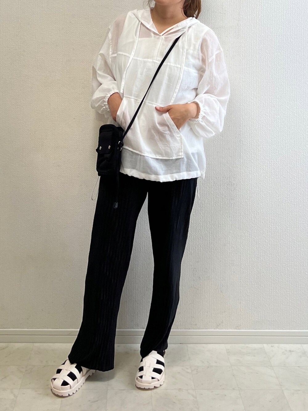 ブラック系のショルダーバッグ、ブラック系のその他パンツ、ホワイト系のサンダルを着用したレディースの春コーディネートの2枚目の写真