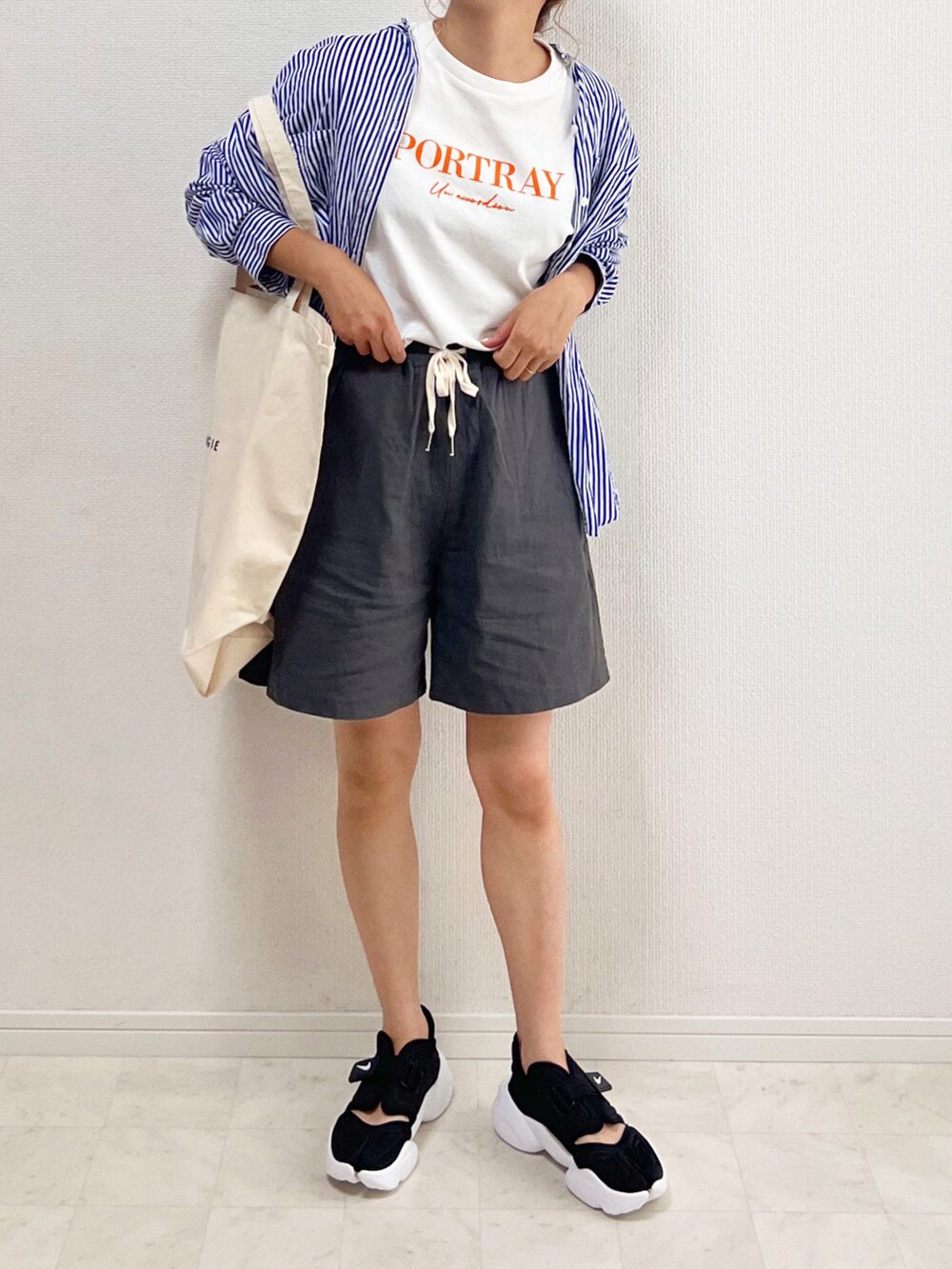 ブルー系のシャツ/ブラウス、グレー系のその他パンツ、ホワイト系のトートバッグを着用したレディースの夏コーディネートの2枚目の写真