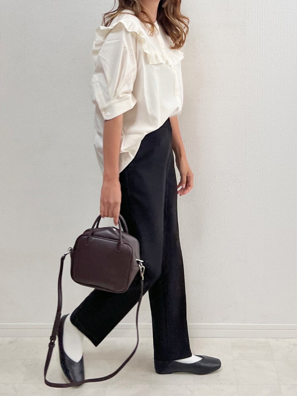 ホワイト系のシャツ/ブラウス、ブラック系のスラックス、ブラウン系のボストンバッグを着用したレディースの夏コーディネートの2枚目の写真
