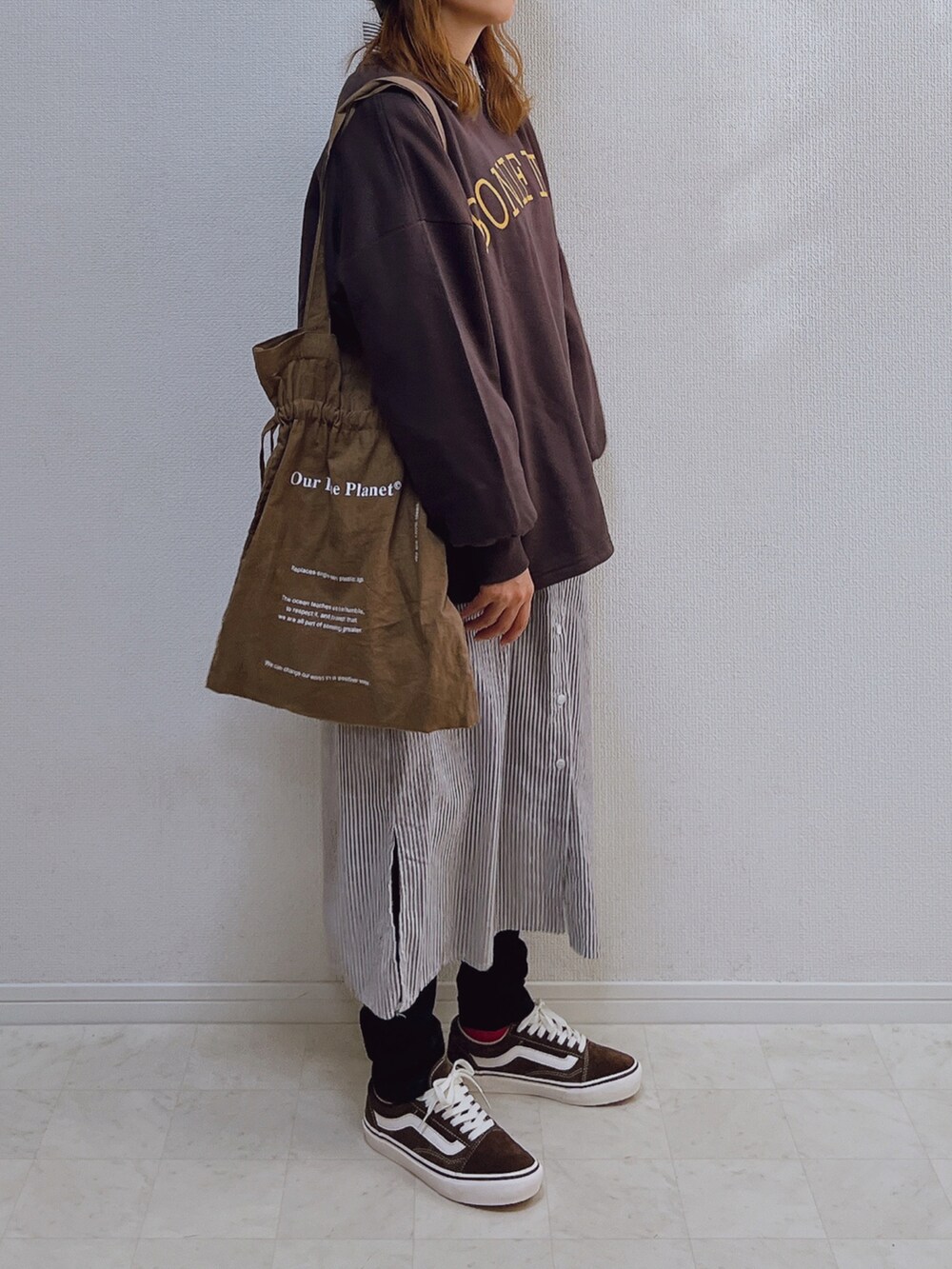 グレー系のスウェット、ブラウン系のシャツワンピース、ブラウン系のスニーカーを着用したレディースの秋コーディネートの2枚目の写真