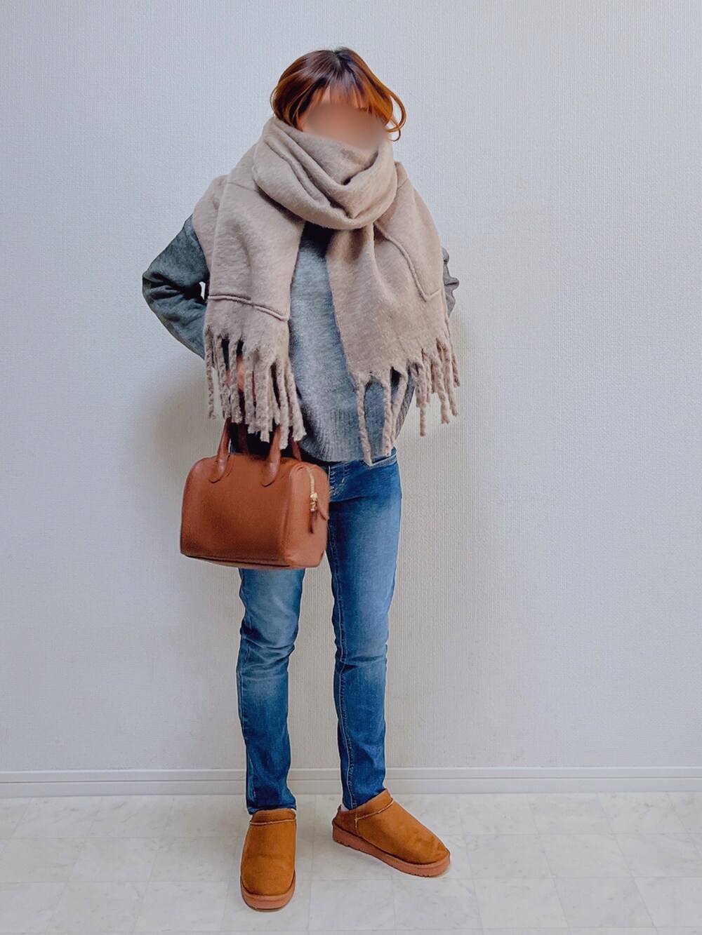 グレー系のニット/セーター、イエロー系のブーツ、ブラウン系のマフラーを着用したレディースの冬コーディネートの2枚目の写真
