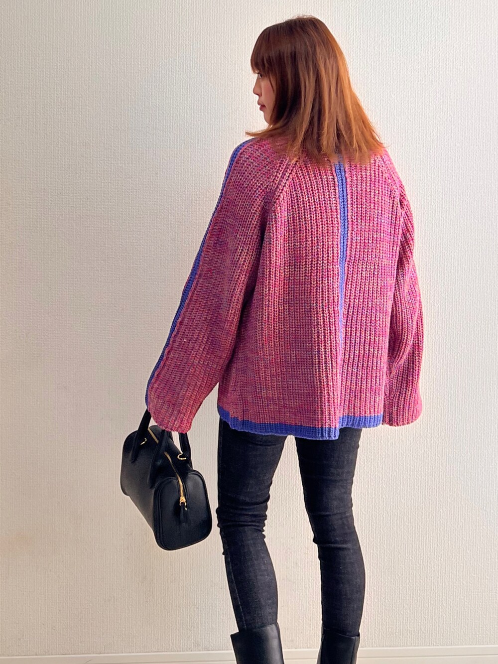 ピンク系のニット/セーター、ブラック系のブーツを着用したレディースの秋コーディネートの2枚目の写真