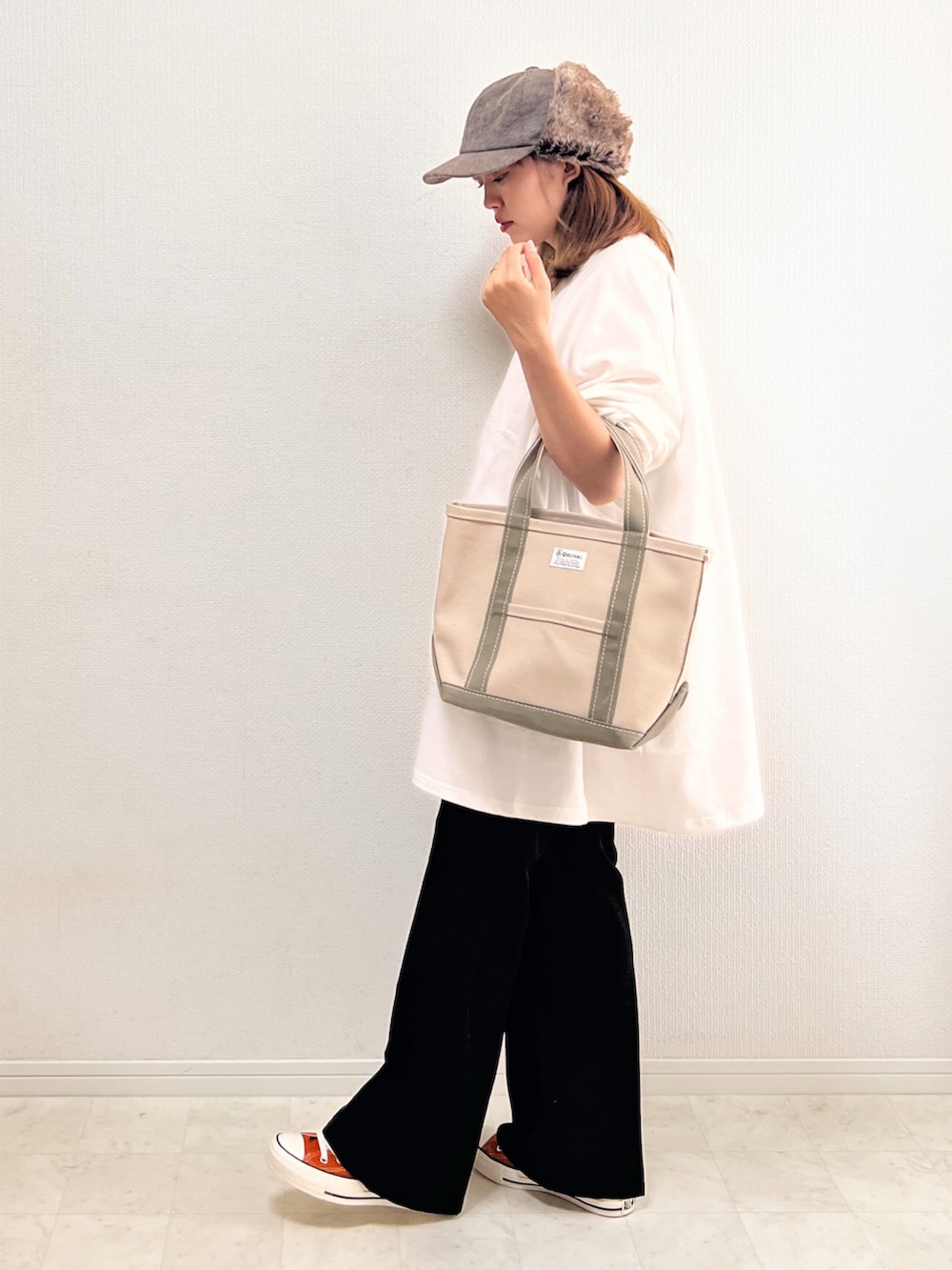 ホワイト系のスウェット、ブラック系のその他パンツ、オレンジ系のスニーカーを着用したレディースの秋コーディネートの3枚目の写真