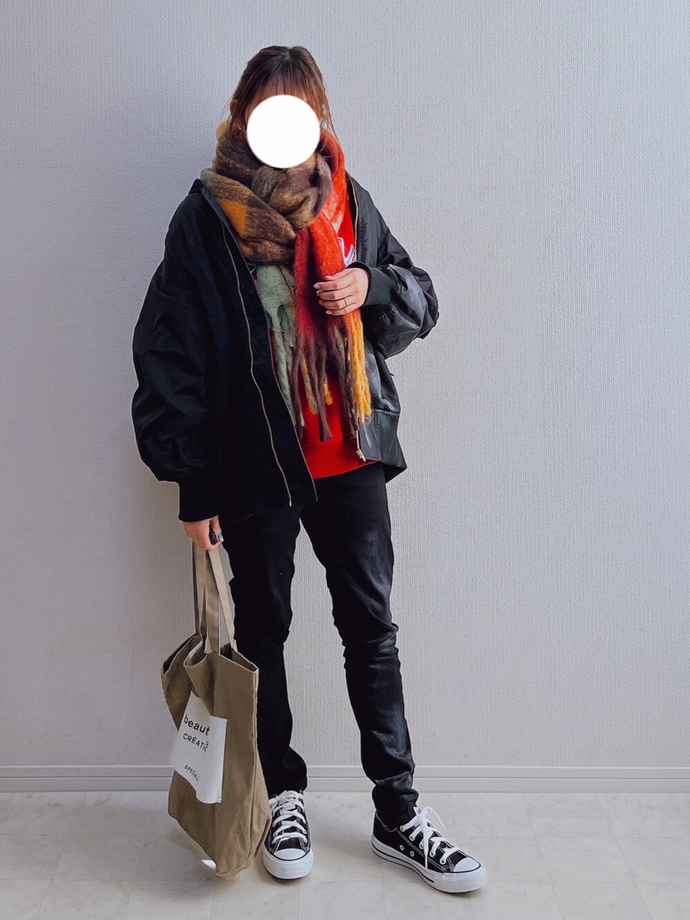 ブラック系のブルゾン、ベージュ系のトートバッグ、ブラック系のスニーカーを着用したレディースの冬コーディネートの2枚目の写真