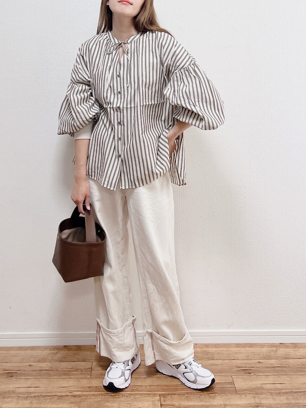 ベージュ系のシャツ/ブラウス、ホワイト系のスニーカー、ブラウン系のバッグを着用したレディースの春コーディネートの3枚目の写真