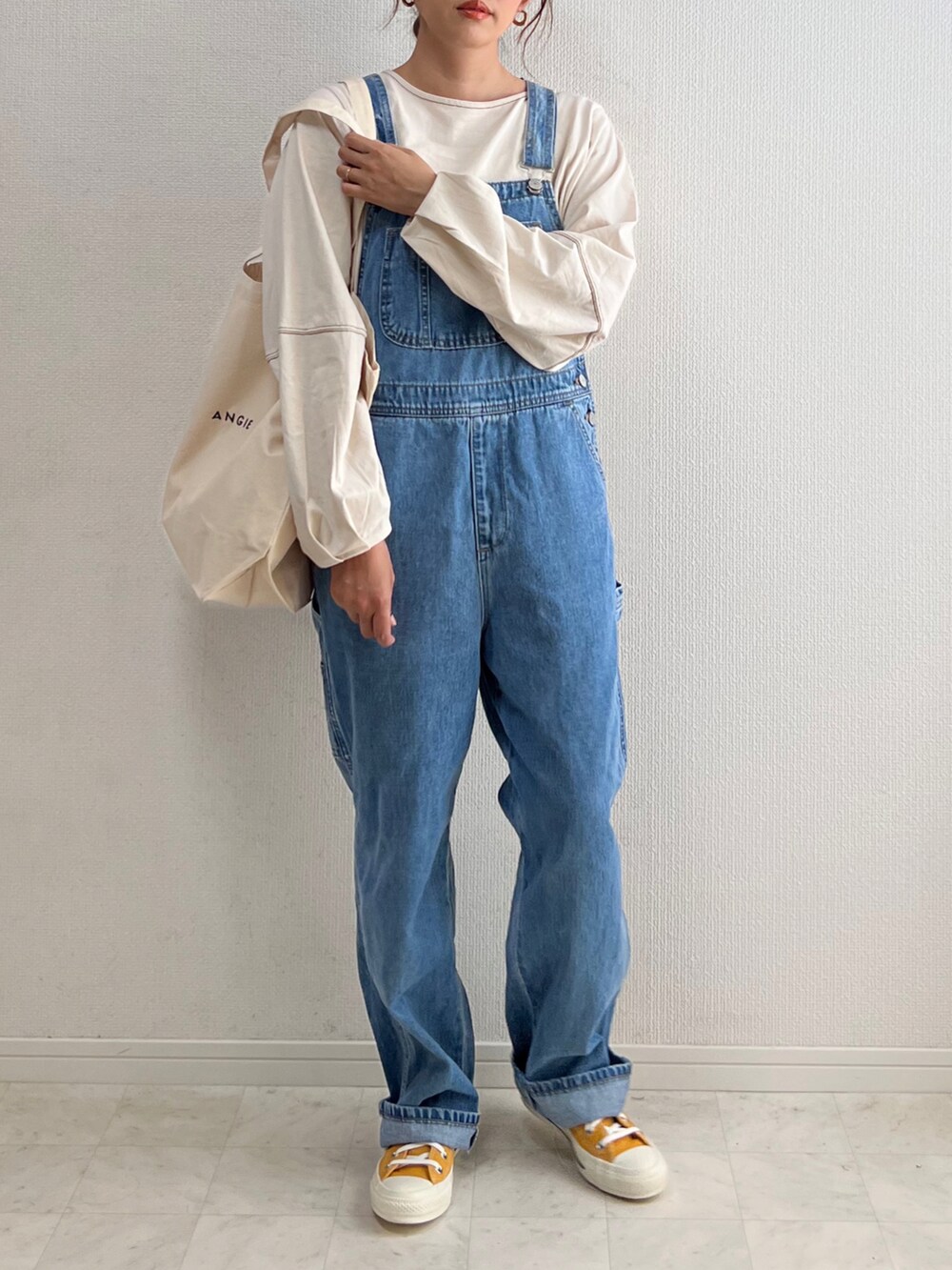 ベージュ系のTシャツ/カットソー、ブルー系のサロペット/オーバーオール、ホワイト系のトートバッグを着用したレディースの春コーディネートの4枚目の写真