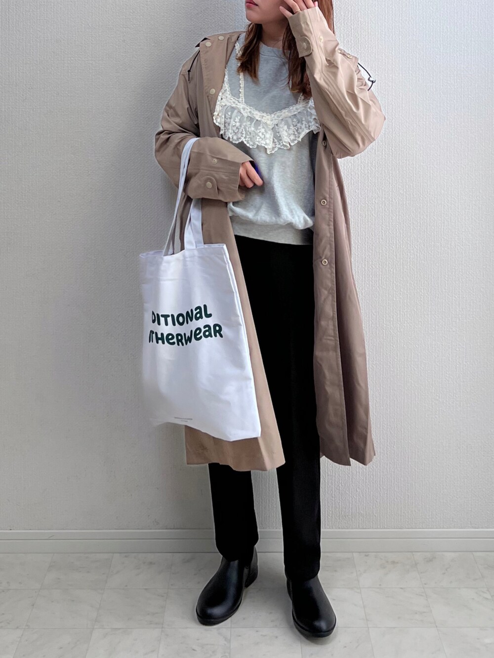 グレー系のスウェット、ブラック系のスラックス、ホワイト系のトートバッグを着用したレディースの春コーディネートの2枚目の写真