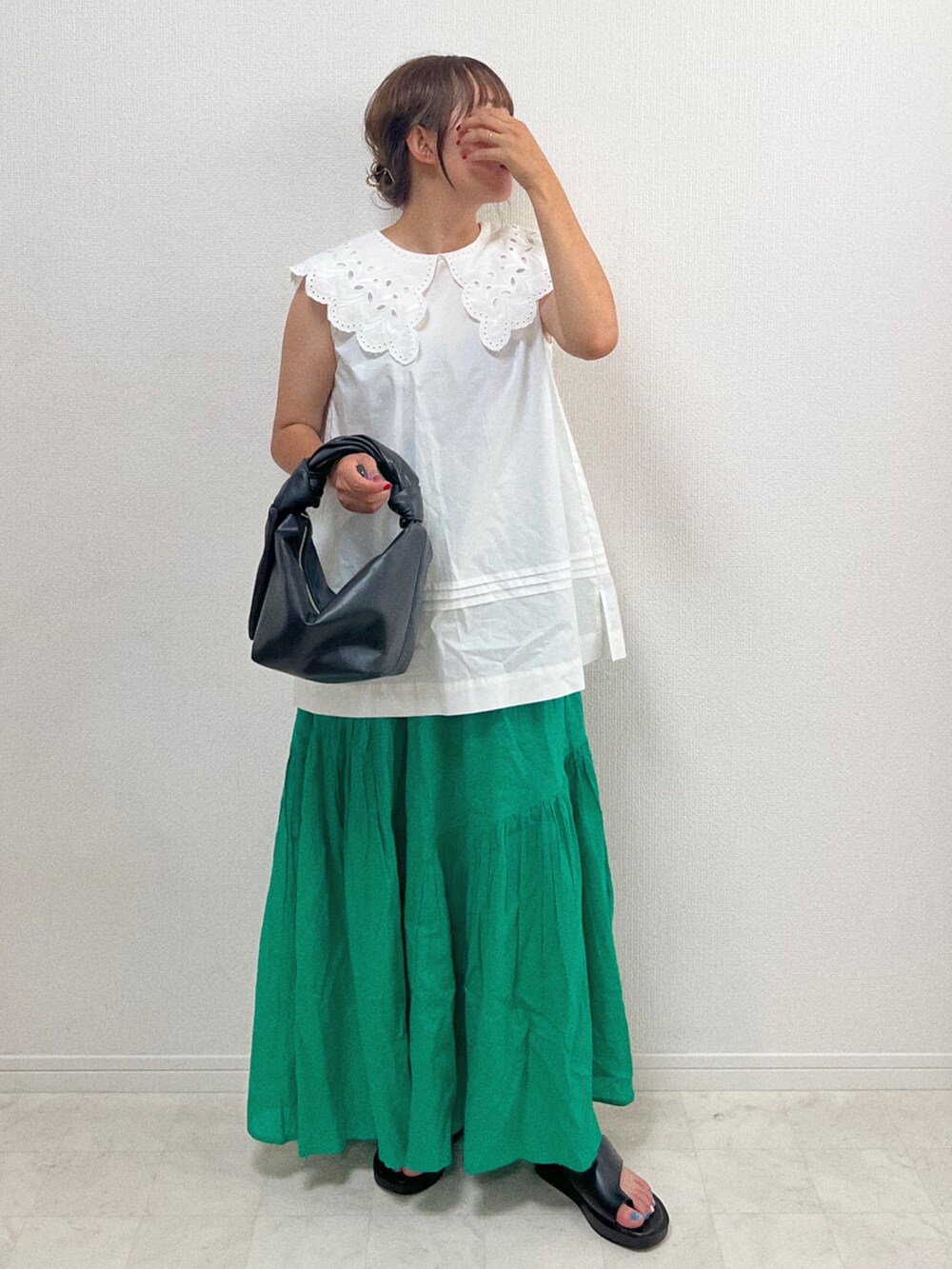 ホワイト系のシャツ/ブラウス、グリーン系のスカート、ブラック系のバッグを着用したレディースの夏コーディネートの2枚目の写真