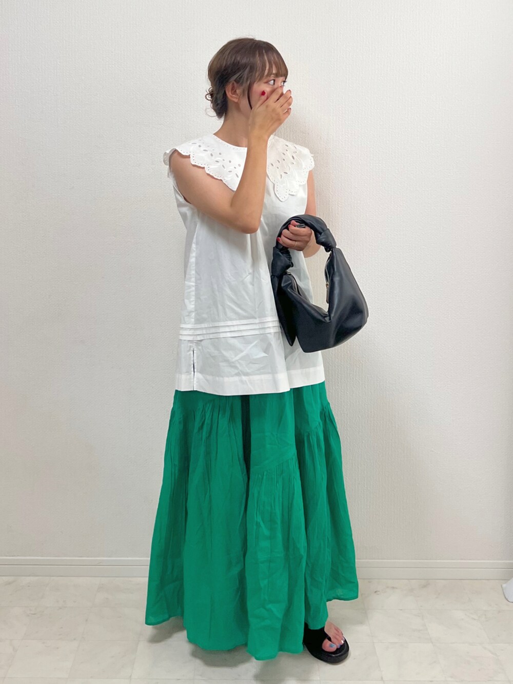 ホワイト系のシャツ/ブラウス、グリーン系のスカート、ブラック系のバッグを着用したレディースの夏コーディネートの3枚目の写真