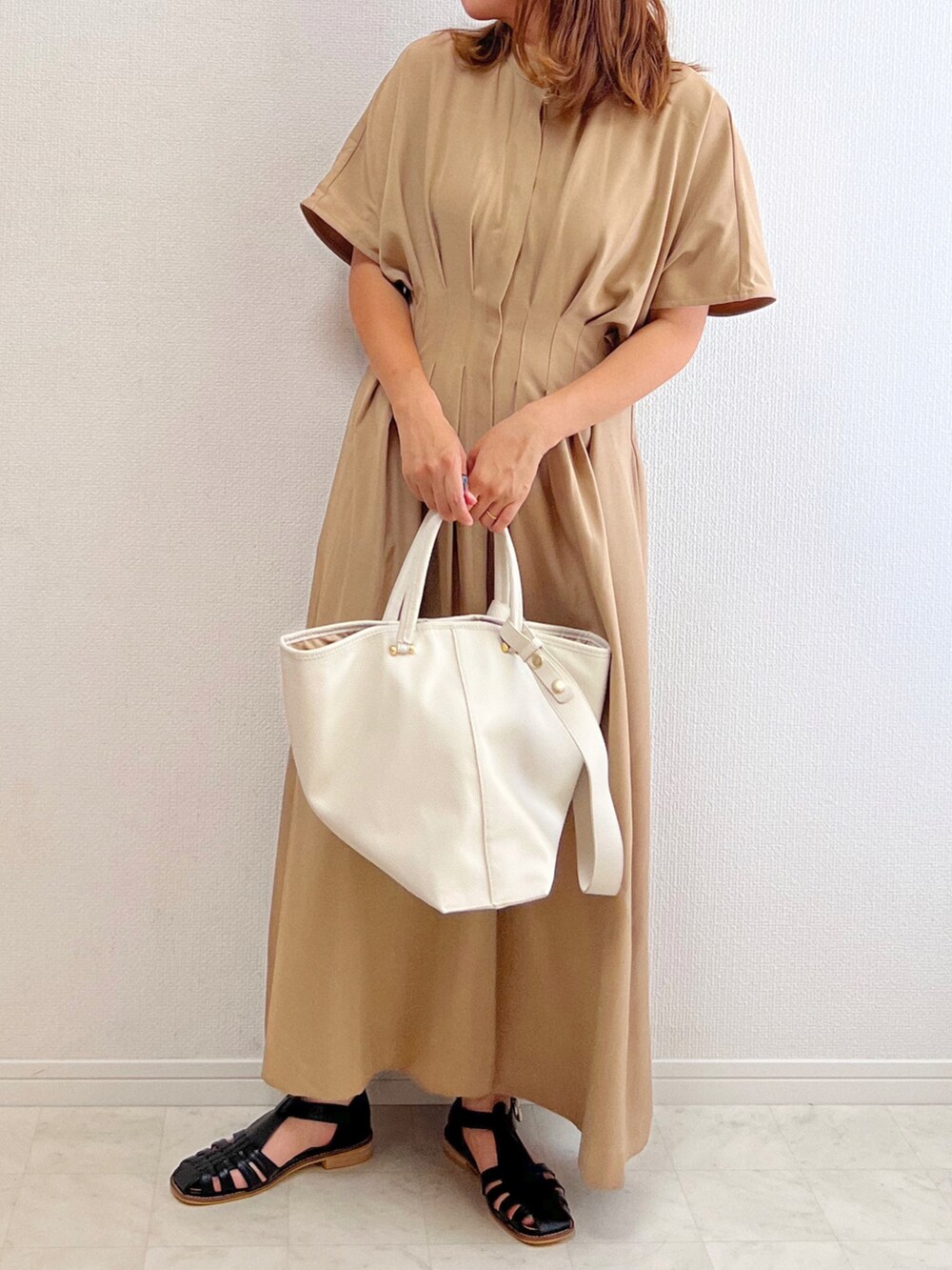 ベージュ系のワンピース、ブラック系のサンダルを着用したレディースの夏コーディネートの2枚目の写真