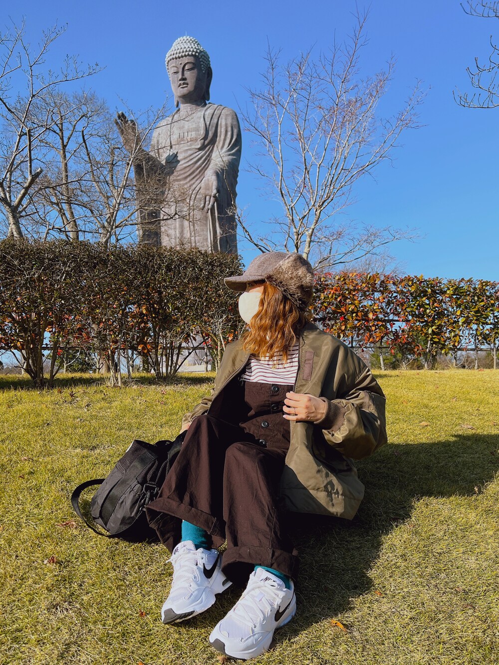 グリーン系のブルゾン、ブラック系のサロペット/オーバーオール、ホワイト系のその他トップスを着用したレディースの冬コーディネートの3枚目の写真