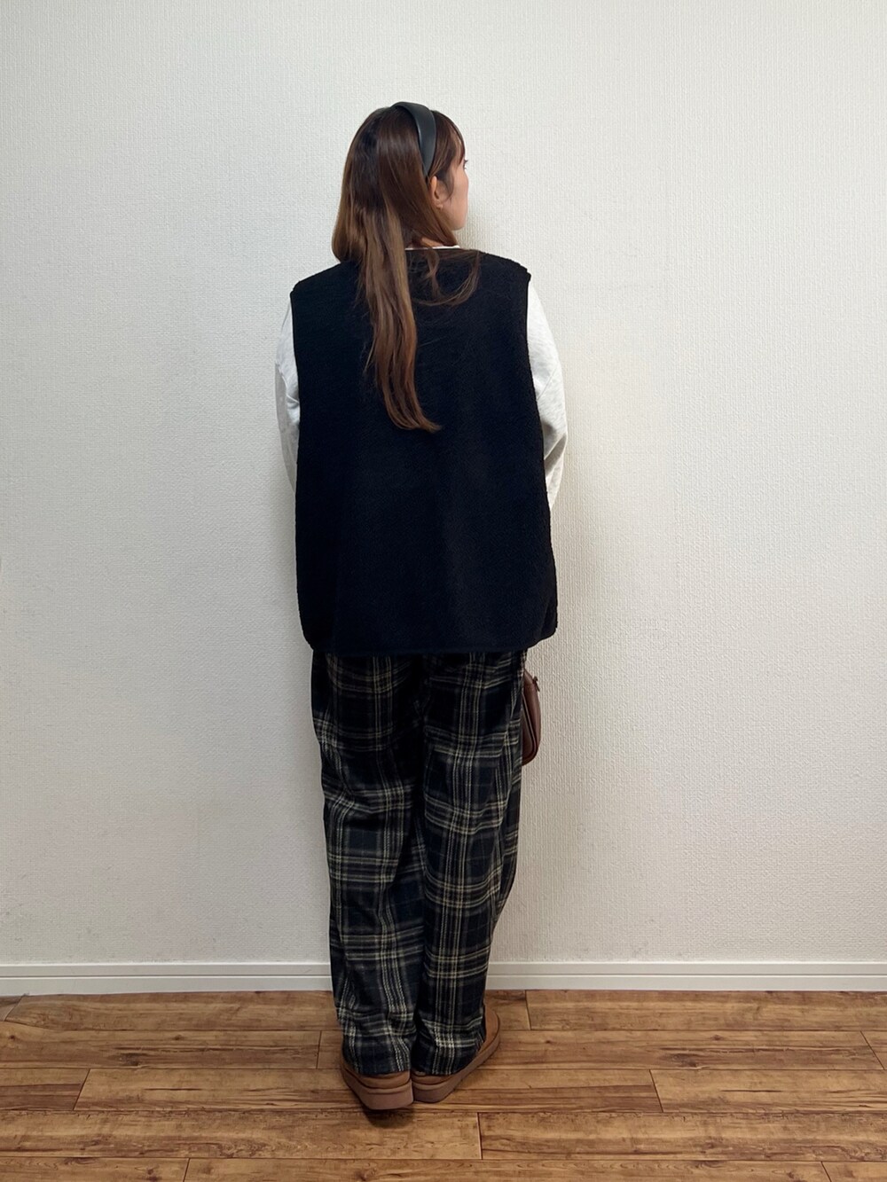 ブラック系のベストを着用したレディースの秋コーディネートの3枚目の写真