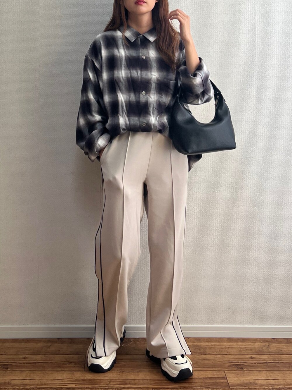 ブラック系のシャツ/ブラウス、ベージュ系のスウェットパンツ、ブラック系のハンドバッグを着用したレディースの秋コーディネートの3枚目の写真