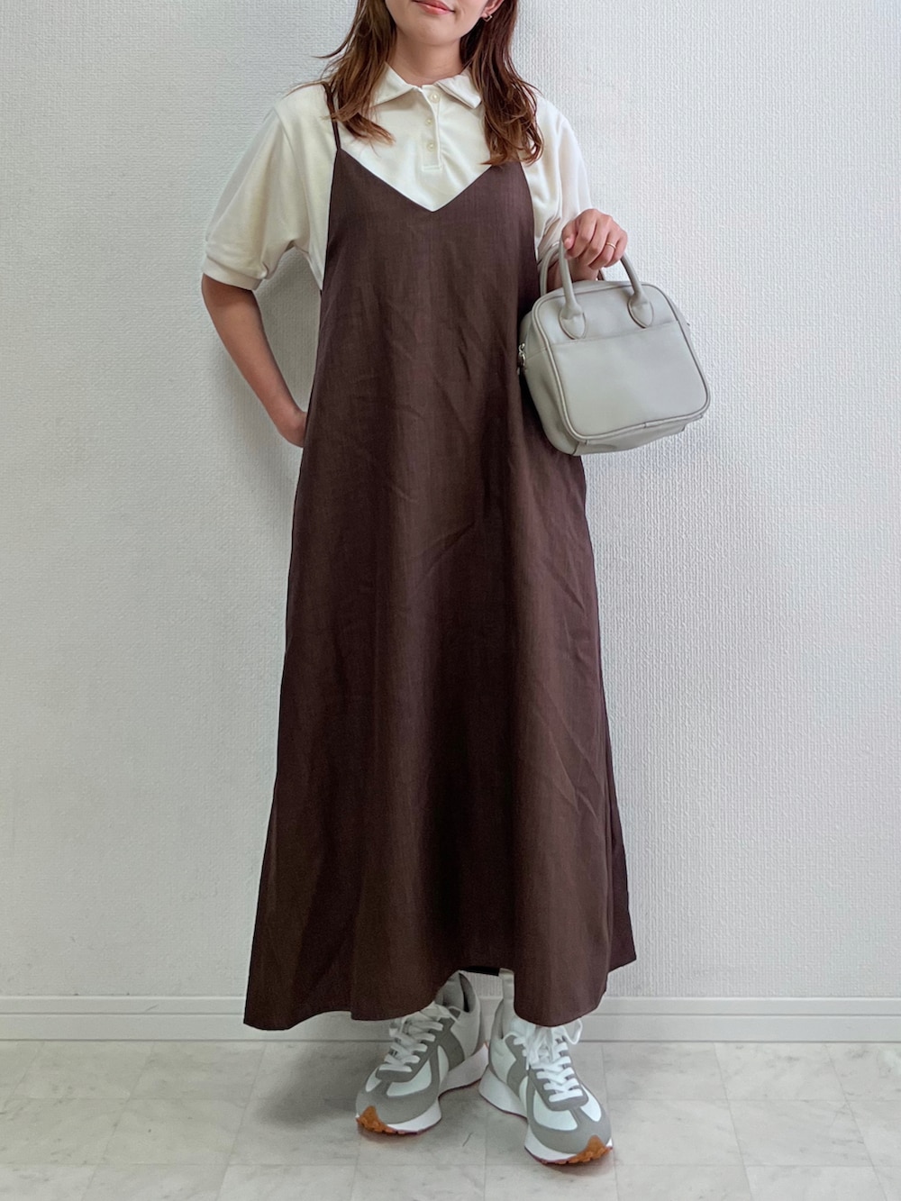 ブラウン系のワンピース/ドレス、ホワイト系のトップス、ブラック系のバッグを着用したレディースの春コーディネートの2枚目の写真