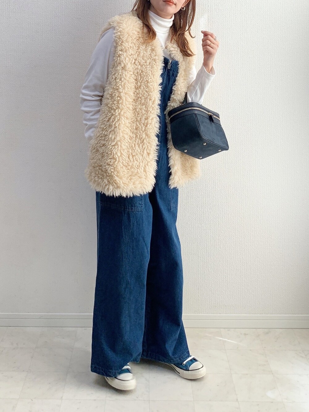 ブルー系のオールインワン・サロペット、グリーン系のシャツ/ブラウス、ブラック系のバッグを着用したレディースの冬コーディネートの2枚目の写真