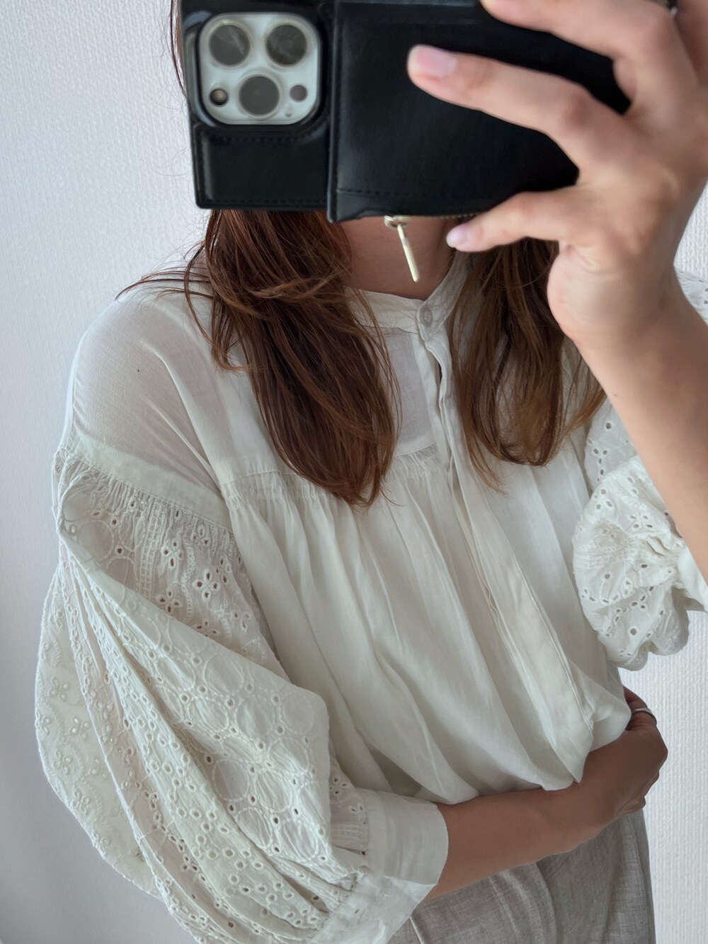 ホワイト系のシャツ/ブラウス、ベージュ系のスラックス、ホワイト系のサンダルを着用したレディースの春コーディネートの4枚目の写真