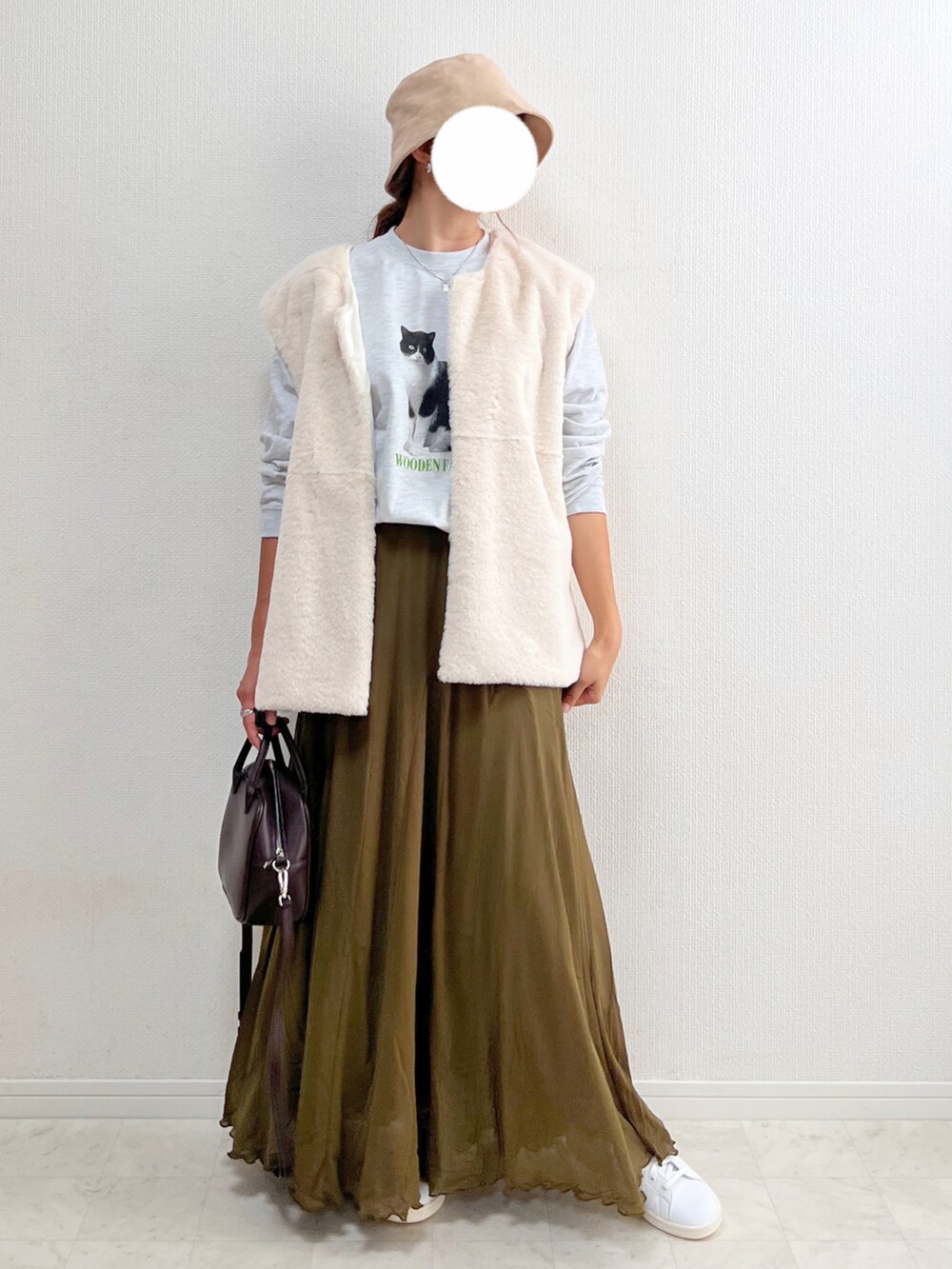 グレー系のTシャツ/カットソー、グリーン系のスカート、ブラウン系のボストンバッグを着用したレディースの夏コーディネートの2枚目の写真