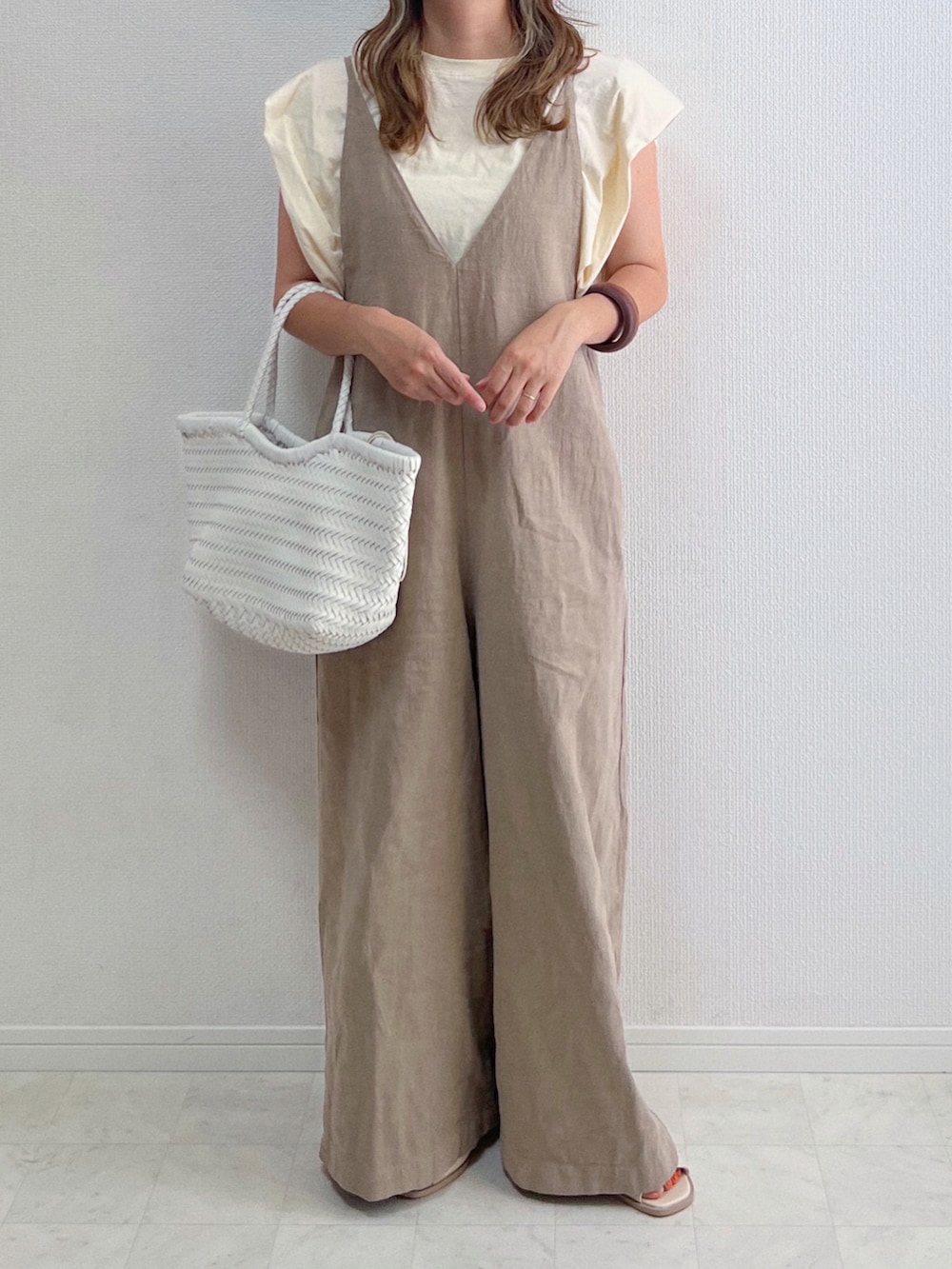 ベージュ系のサロペット/オーバーオール、ベージュ系のTシャツ/カットソー、ホワイト系のトートバッグを着用したレディースの夏コーディネートの2枚目の写真