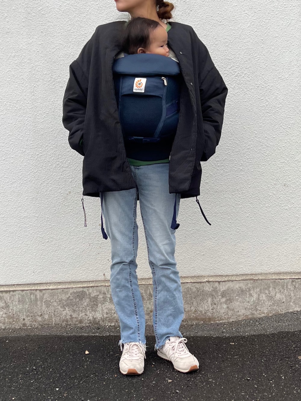 ホワイト系のスニーカー、グリーン系のスウェット、ブラック系のその他アウターを着用したレディースの秋コーディネートの2枚目の写真