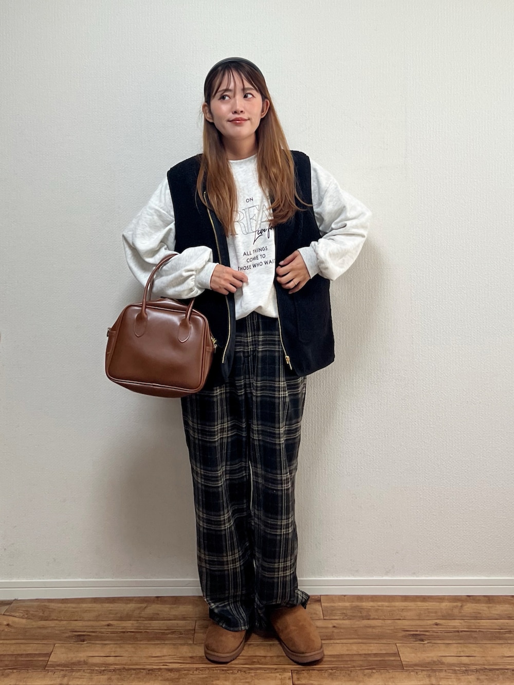 ブラック系のベストを着用したレディースの秋コーディネートの2枚目の写真