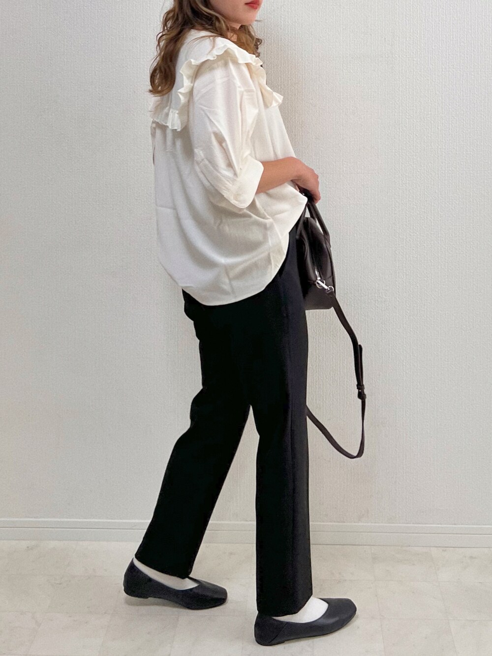 ホワイト系のシャツ/ブラウス、ブラック系のスラックス、ブラウン系のボストンバッグを着用したレディースの夏コーディネートの3枚目の写真