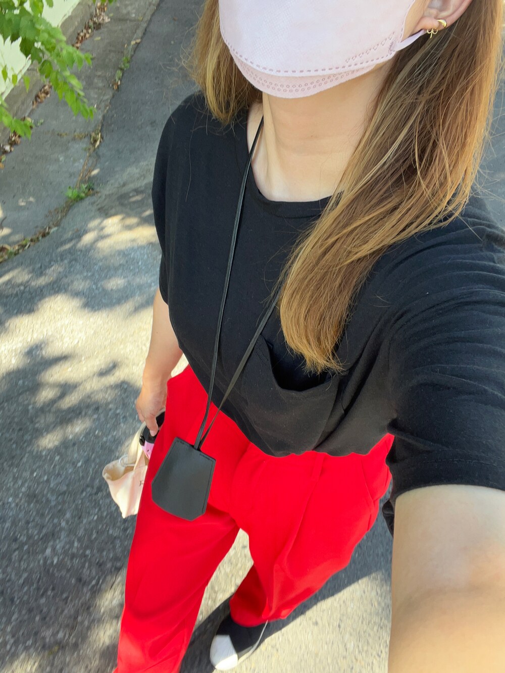 ブラック系のTシャツ/カットソー、レッド系のスラックス、ブラック系のスリッポンを着用したレディースの夏コーディネートの2枚目の写真