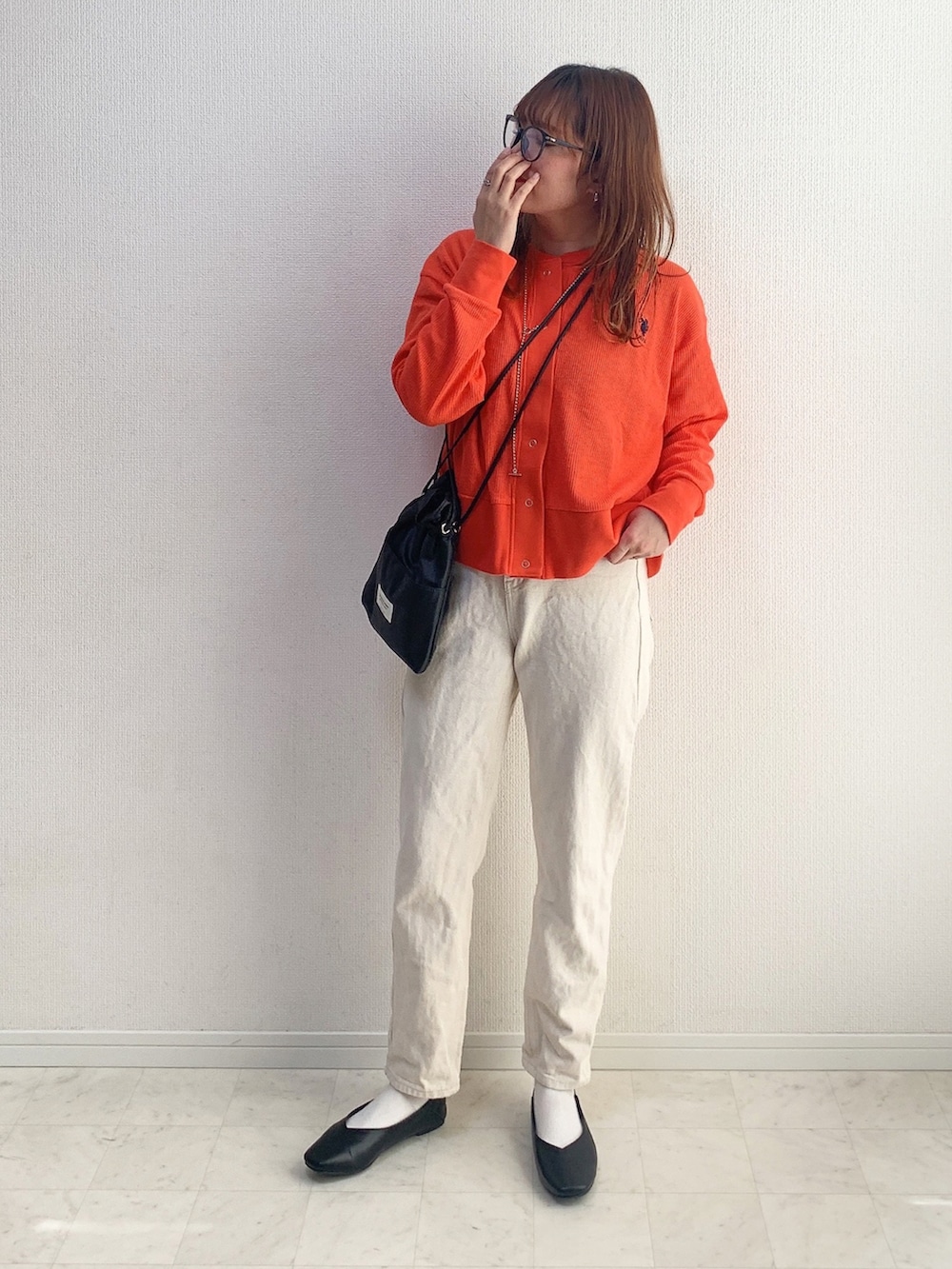 レッド系のカーディガン/ボレロ、ベージュ系のその他パンツ、ブラック系のショルダーバッグを着用したレディースの春コーディネートの2枚目の写真