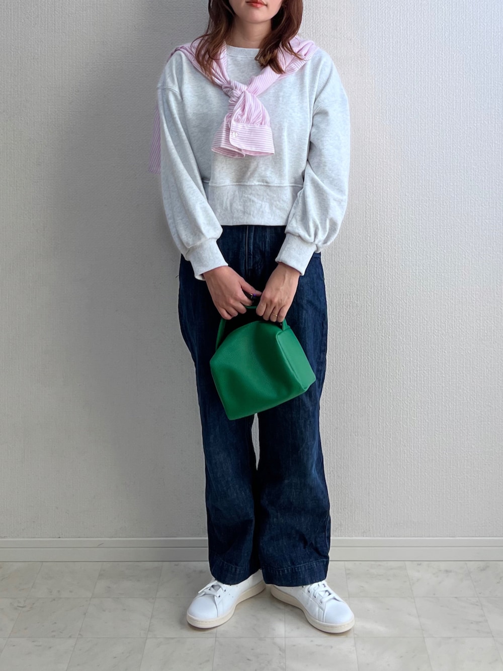 グレー系のスウェット、ピンク系のシャツ/ブラウス、ブルー系のデニムパンツを着用したレディースの春コーディネートの3枚目の写真