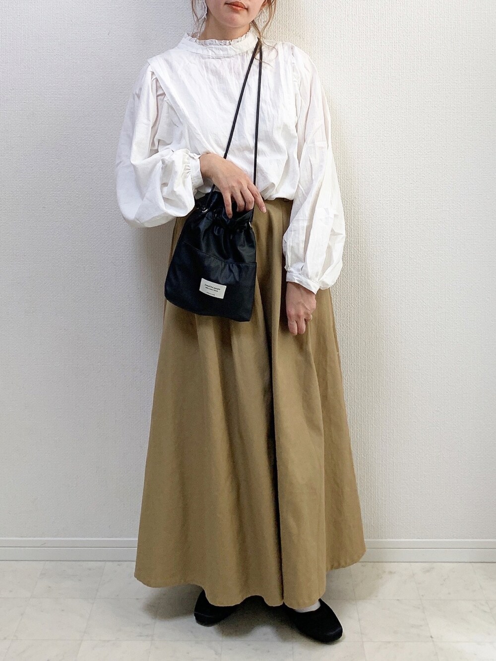 ホワイト系のシャツ/ブラウス、ブラック系のショルダーバッグ、ベージュ系のスカートを着用したレディースの冬コーディネートの2枚目の写真