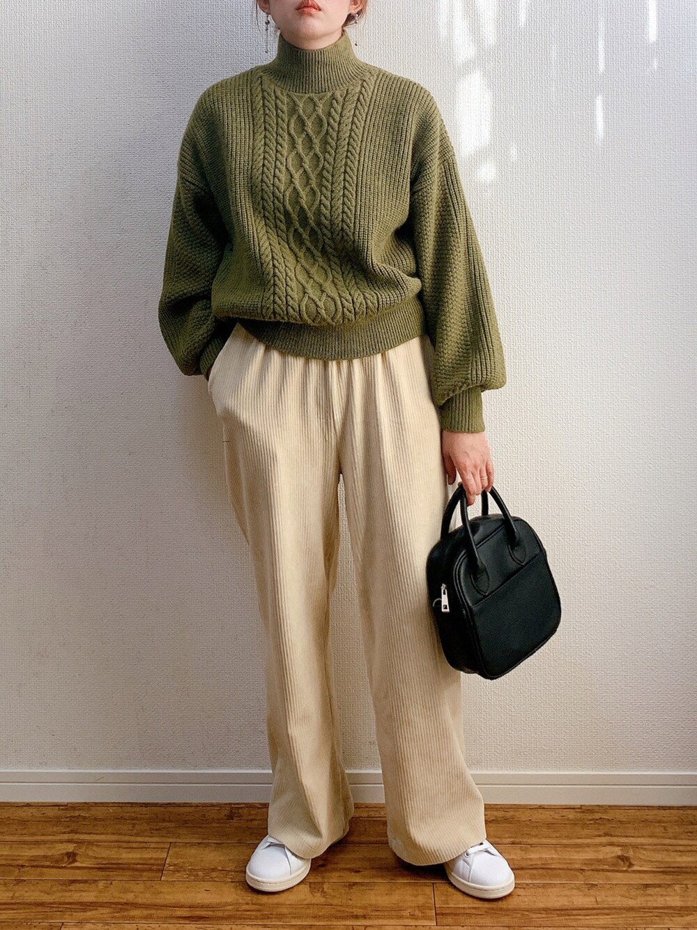 グリーン系のニット/セーター、ホワイト系のその他パンツ、ブラック系のバッグを着用したレディースの冬コーディネートの2枚目の写真
