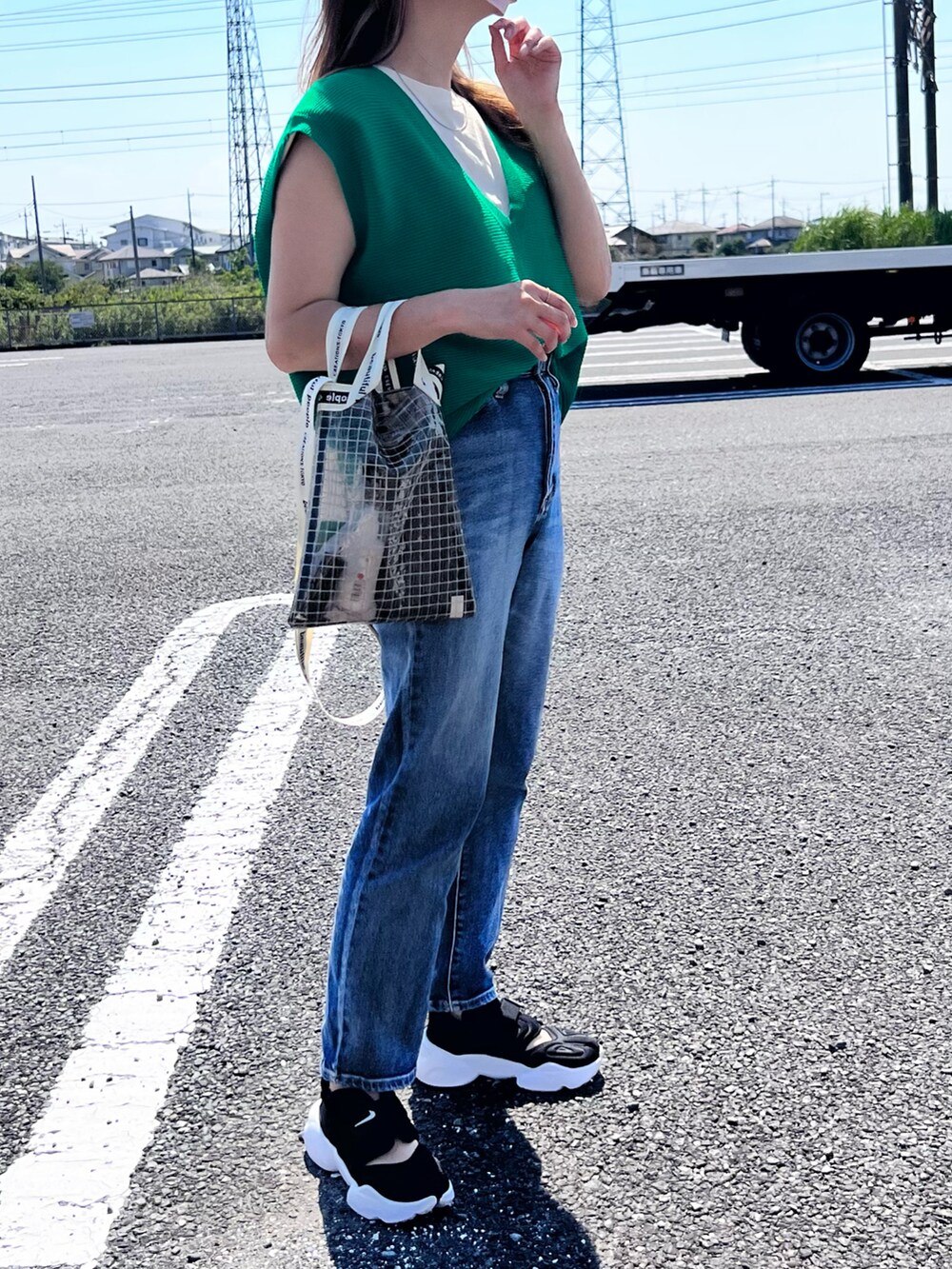 グリーン系のベスト、ベージュ系のTシャツ/カットソー、ブラック系のショルダーバッグを着用したレディースの夏コーディネートの2枚目の写真