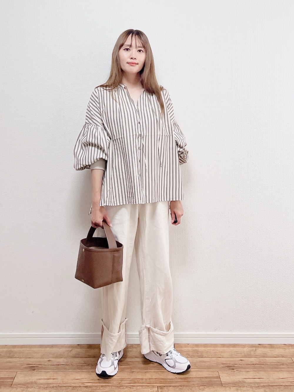 ベージュ系のシャツ/ブラウス、ホワイト系のスニーカー、ブラウン系のバッグを着用したレディースの春コーディネートの2枚目の写真