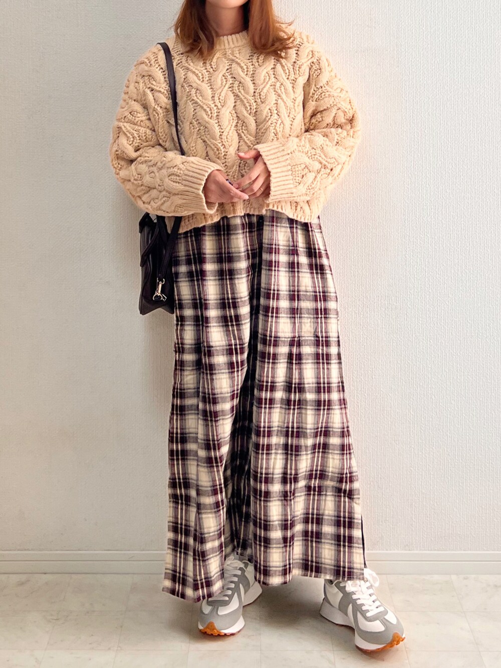 ベージュ系のニット/セーター、ブラウン系のボストンバッグ、レッド系のワンピースを着用したレディースの秋コーディネートの3枚目の写真