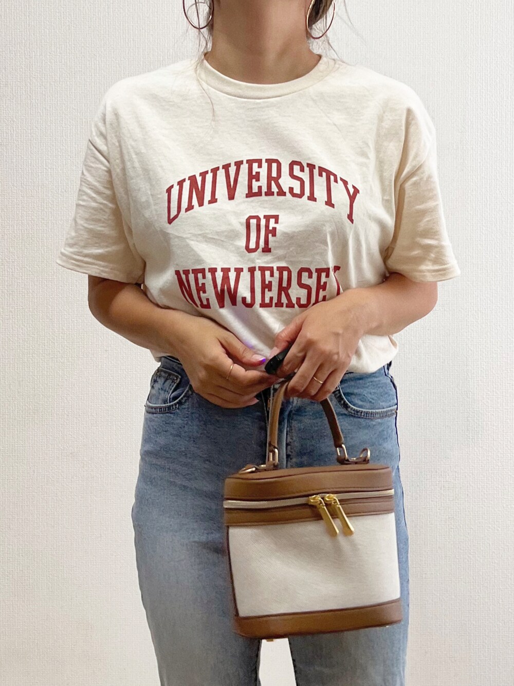 ベージュ系のTシャツ/カットソー、ブルー系のデニムパンツ、ブラウン系のバッグを着用したレディースの夏コーディネートの3枚目の写真