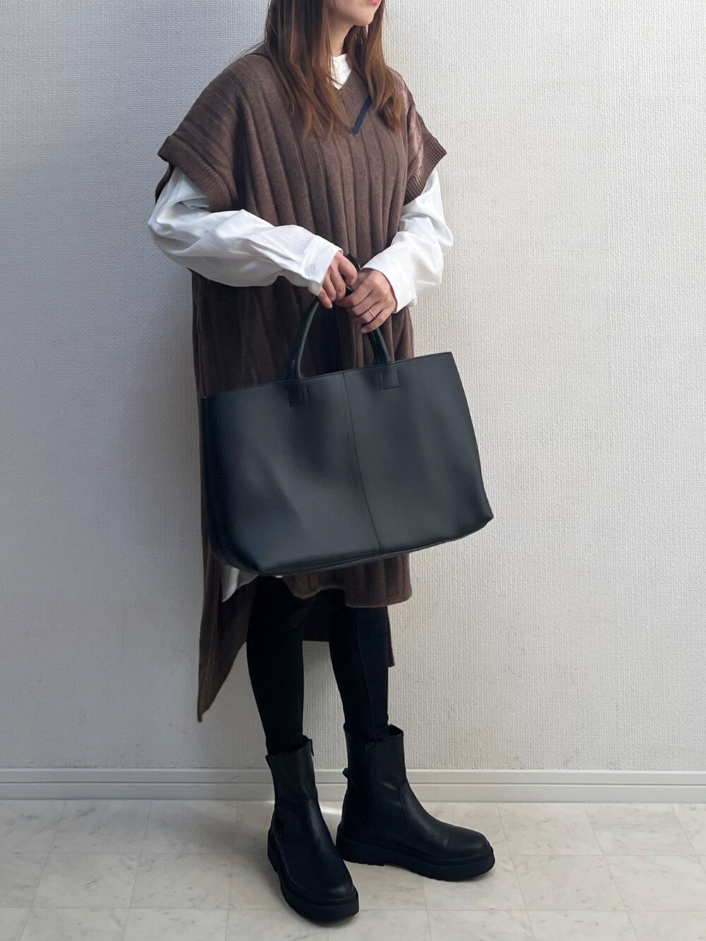 ブラウン系のベストを着用したレディースの冬コーディネートの2枚目の写真