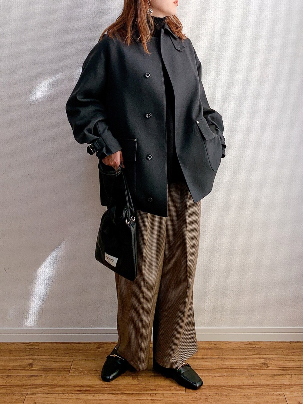 グレー系のブルゾン、ブラック系のニット/セーター、ブラウン系のパンツを着用したレディースの冬コーディネートの2枚目の写真