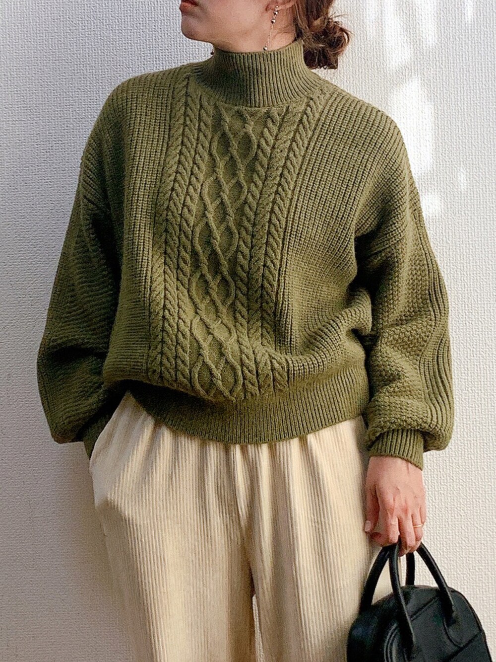 グリーン系のニット/セーター、ホワイト系のその他パンツ、ブラック系のバッグを着用したレディースの冬コーディネートの4枚目の写真