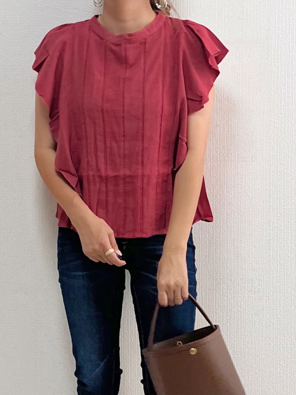 ピンク系のシャツ/ブラウス、ブルー系のデニムパンツ、ブラウン系のバッグを着用したレディースの夏コーディネートの3枚目の写真