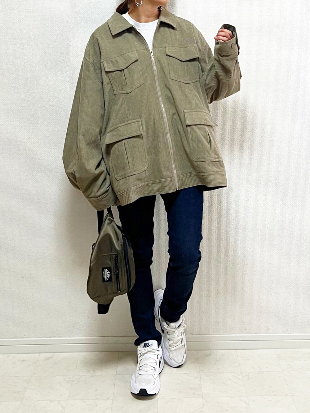 グリーン系のブルゾン、ホワイト系のTシャツ/カットソー、ホワイト系のスニーカーを着用したレディースの秋コーディネートの3枚目の写真