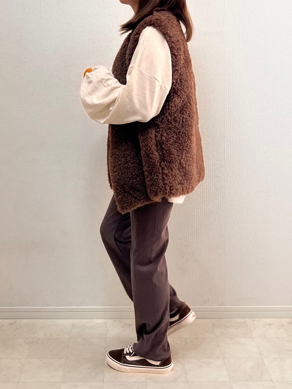 ベージュ系のスウェット、ブラウン系のベスト、ブラウン系のその他パンツを着用したレディースの秋コーディネートの3枚目の写真