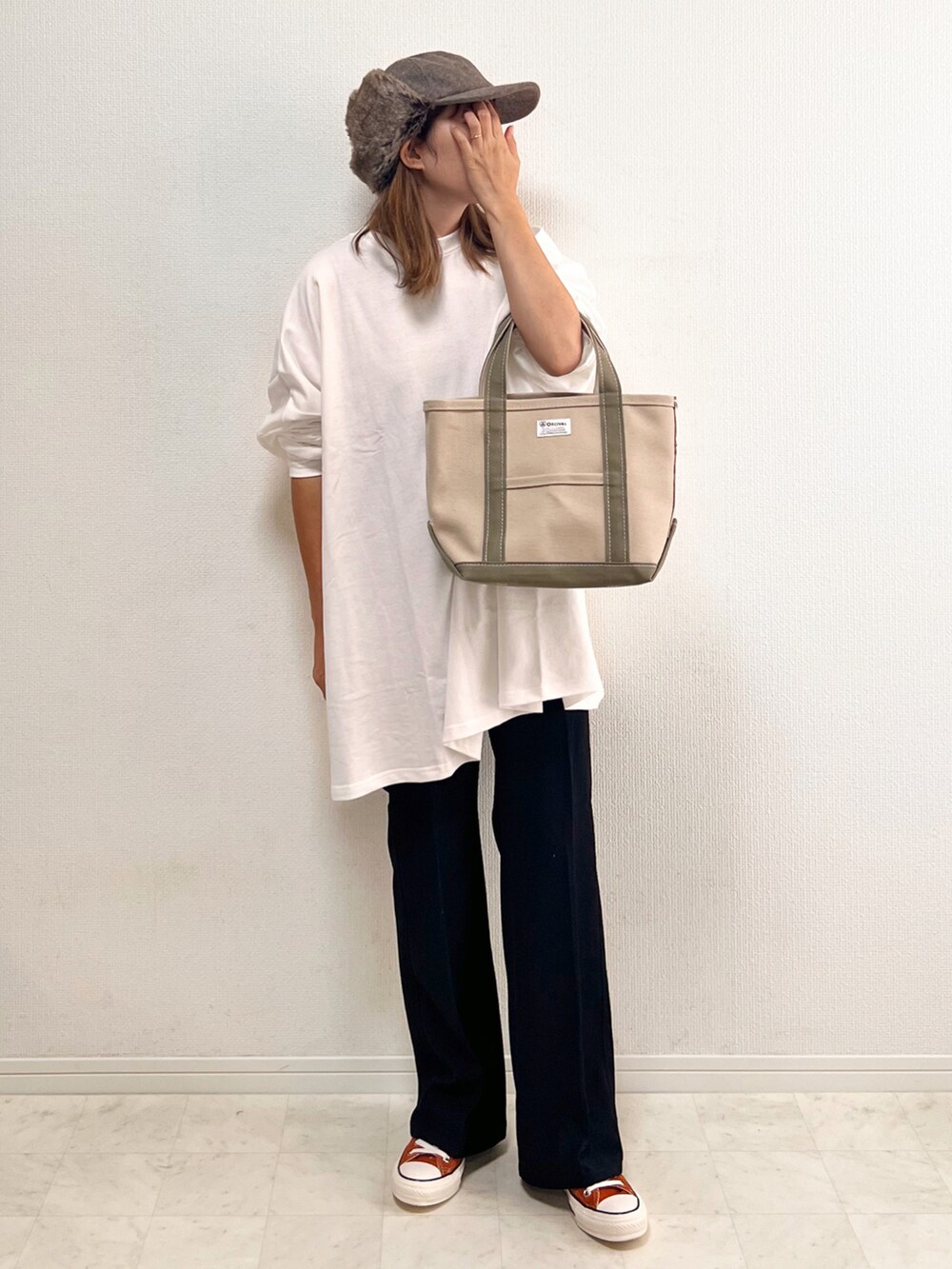 ホワイト系のスウェット、ブラック系のその他パンツ、オレンジ系のスニーカーを着用したレディースの秋コーディネートの2枚目の写真