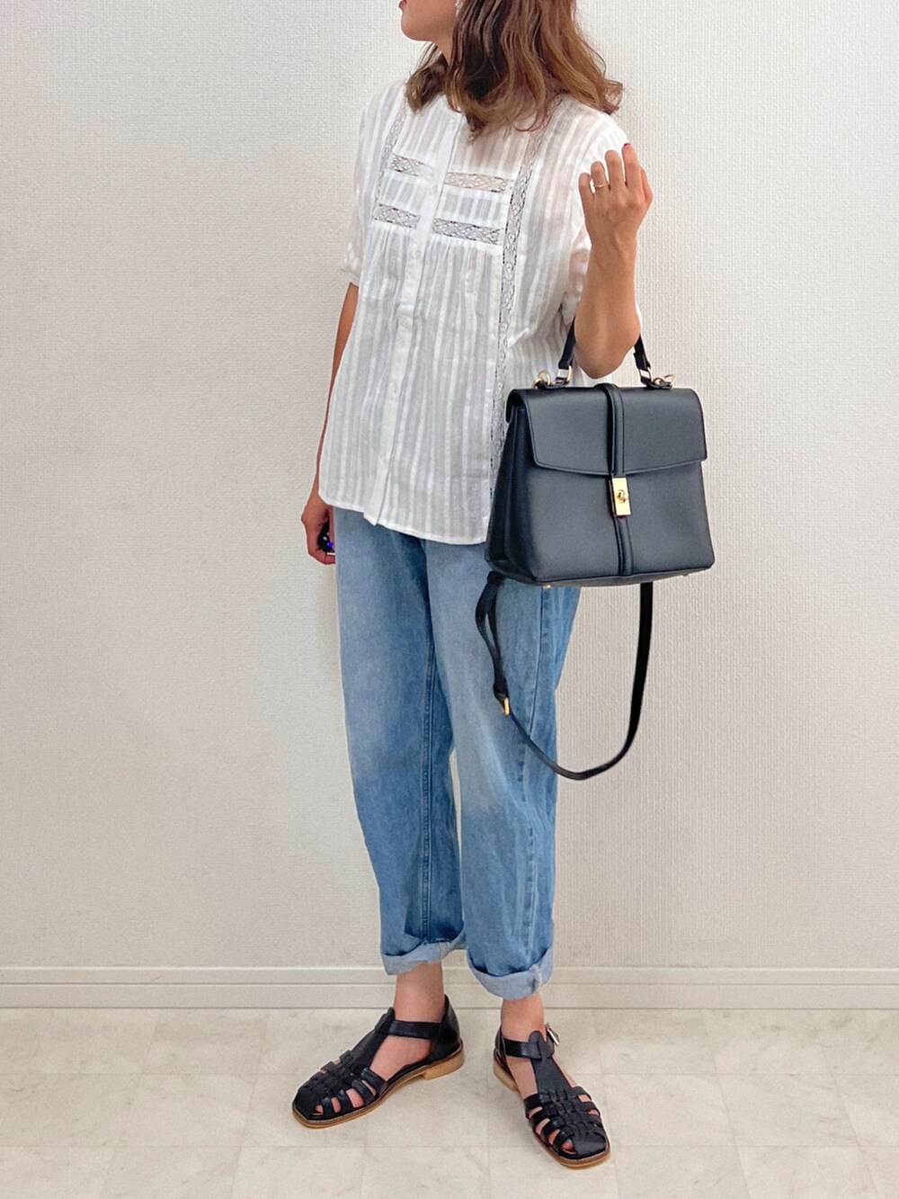 ホワイト系のシャツ/ブラウス、ブルー系のデニムパンツ、ブラック系のサンダルを着用したレディースの夏コーディネートの3枚目の写真