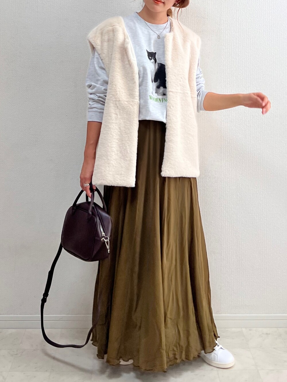 グレー系のTシャツ/カットソー、グリーン系のスカート、ブラウン系のボストンバッグを着用したレディースの夏コーディネートの3枚目の写真