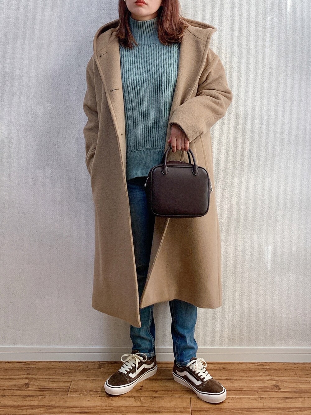 ブルー系のニット/セーター、ブラウン系のボストンバッグ、ベージュ系のその他アウターを着用したレディースの秋コーディネートの2枚目の写真