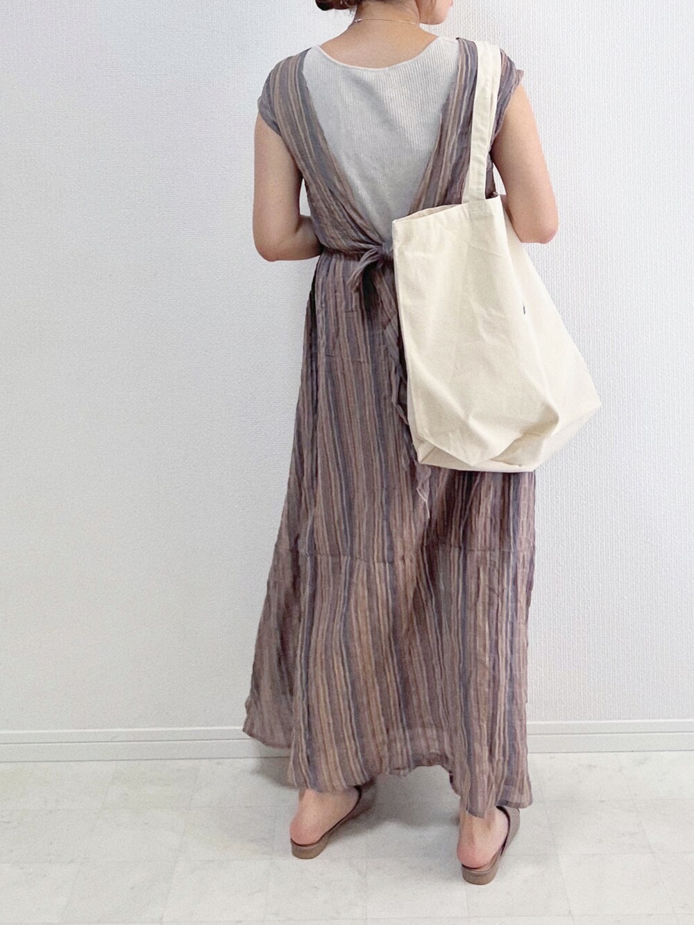 グレー系のワンピース、ホワイト系のトートバッグ、ベージュ系のシューズを着用したレディースの春コーディネートの3枚目の写真